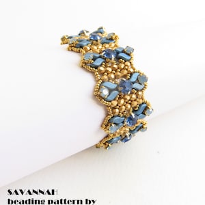 Może przedstawiać: Bransoletka z koralików złotych i niebieskich w falisty wzór. Bransoletka wykonana jest z małych koralików nasiennych i większych fasetowanych koralików. Tekst "SAVANNAH beading pattern by bizSutterie" jest widoczny pod bransoletką.
