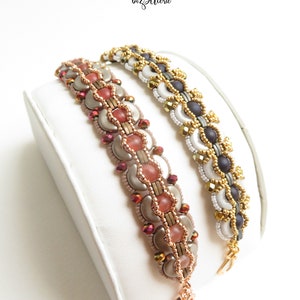 Peut inclure: Deux bracelets en perles avec des perles dorées, argentées et noires. Les bracelets sont sur un présentoir blanc. Le texte "SADIE BEADING PATTERN BY bizSutterie" est visible au-dessus des bracelets.