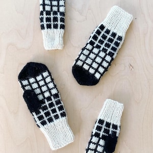 May include: Four pairs of black and white knitted mittens with a chequered pattern. The mittens are made from a soft, warm yarn and are ideal for keeping your hands warm in the winter.