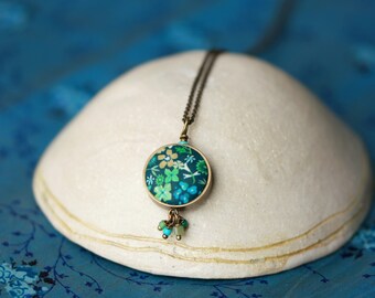 necklace necklace in brass and round pendant with green floral pattern decorated with tassels, collection 'Amicie'