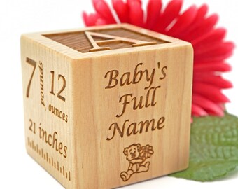May include: A wooden baby block with engraved details. The block features the letter "A" on top, with the words "Baby's Full Name" and a teddy bear illustration on one side. The block also displays the baby's weight as 7 pounds 12 ounces and length as 21 inches.