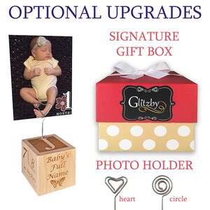 Peut inclure: Un porte-photo en bois avec un clip en forme de c&oelig;ur, une bo&icirc;te cadeau rouge &agrave; pois blancs avec un n&oelig;ud blanc et une pancarte noire et blanche qui dit "Glitzby". Le porte-photo est grav&eacute; avec le texte "Baby's Full Name", "7", "8", et "21 inches".