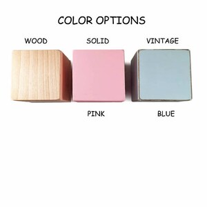Peut inclure: Trois blocs de bois montrant les options de couleur pour un produit. Les blocs sont &eacute;tiquet&eacute;s "Bois", "Solide" et "Vintage". Les couleurs sont bois naturel, rose et bleu.