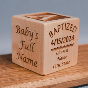 May include: A wooden block with the text "Baby's Full Name" on one side and "Baptized 4/15/2024 Church Name City, State" on the other side.