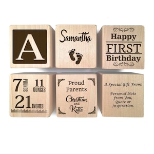 Peut inclure: Blocs en bois avec du texte grav&eacute;, y compris le nom Samantha, la lettre A, les mots "Happy First Birthday", "Proud Parents Christian and Katie", et "7 pounds 11 ounces 21 inches".