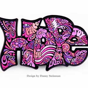 May include: A pink and purple enamel pin featuring the word "HOPE" in a stylised font. The letters are filled with intricate designs and patterns, including flowers, peace signs, and the words "peace", "love", and "joy".