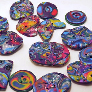May include: A collection of 14 colorful, handmade buttons with a variety of swirling patterns and glitter accents. The buttons are made of polymer clay and have a unique, abstract design.