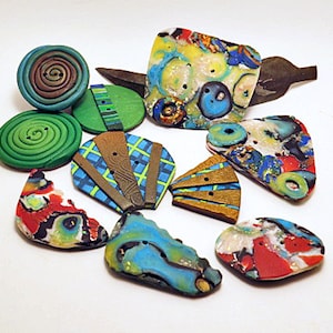 May include: Assortment of colorful, handmade polymer clay buttons with various patterns and designs. The buttons are in shades of green, blue, red, brown, and white.