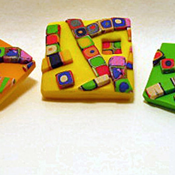 Brooches. 3 colourful brooches from the Metro range. Green, Orange and Yellow brooches with colourful strands of dots overlay.