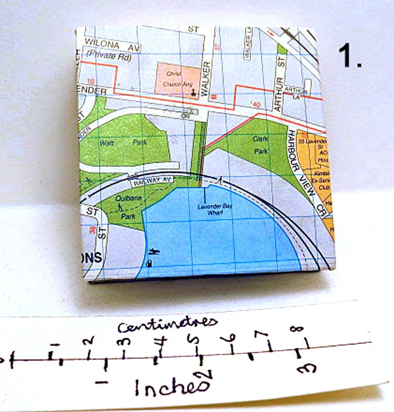 May include: A map of a small area with a blue body of water labeled "Lavender Bay What" and a green park labeled "Quibarne Park". The map is printed on a white background with black lines and text. The map is approximately 3 inches wide.
