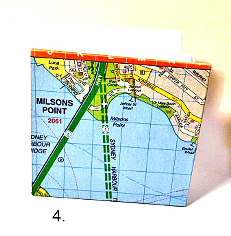 May include: A map of Milson's Point, a suburb of Sydney, Australia. The map shows the location of Milson's Point, Sydney Harbour Bridge, and Luna Park. The map is printed on a blue background with green, yellow, and red lines.