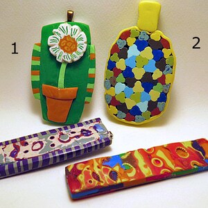 May include: Four colorful polymer clay pendants, each with a unique design. The first pendant is green with a white flower and an orange pot. The second pendant is yellow with a mosaic of blue, green, red, and brown. The third pendant is purple and gray with white stripes. The fourth pendant is red, orange, and yellow with a swirling pattern.