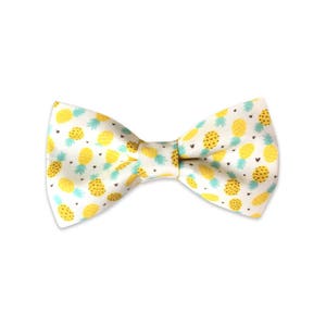 May include: A white bow tie with a yellow pineapple pattern.