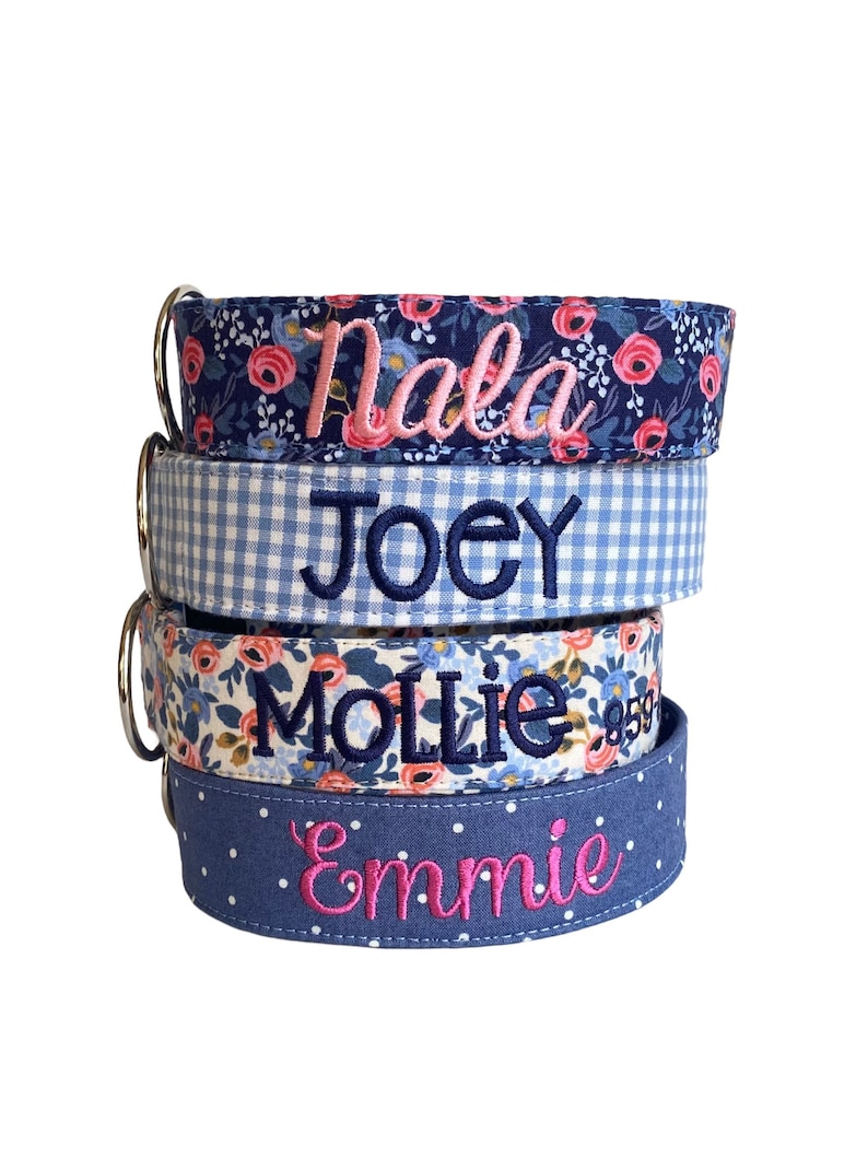 Duke & Fox® personalized embroidered dog collars are handmade with soft, durable fabric layered over sturdy nylon webbing. They feature vibrant patterns — a navy floral with pink roses, classic blue gingham, a vintage floral mix, and a chambray polka dot — each embroidered with names in coordinating thread colors. Designed for comfort and everyday wear, they combine durability, charm, and custom style for dogs of all sizes.