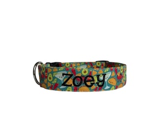 May include: A teal dog collar with a repeating pattern of tacos, avocados, and margaritas. The name "Zoey" is embroidered in black letters across the center of the collar. The collar has a black buckle and a silver metal D-ring.