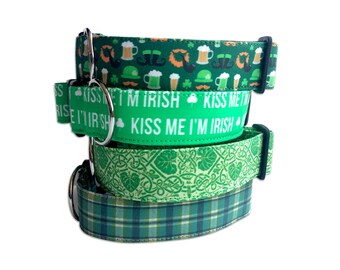 May include: Four dog collars stacked. The top collar is green with a pattern of beer mugs, moustaches, and hats. The second collar says "Kiss Me I'm Irish". The third collar has a Celtic knot pattern. The bottom collar is plaid in shades of green.
