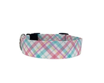 May include: A pastel plaid dog collar with a black buckle and silver metal hardware. The collar features a pattern of white, pink, yellow, and blue intersecting lines. The collar is designed for a pet.
