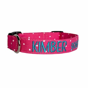 May include: Pink dog collar with white polka dots and the name "KIMBER" embroidered in teal.