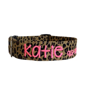 May include: A brown and black leopard print dog collar with the name "Katie" embroidered in pink.