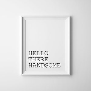 May include: A white framed print with the text "HELLO THERE HANDSOME" in black.
