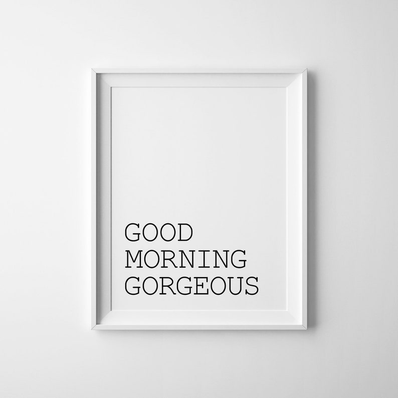 May include: A white framed print with the text "GOOD MORNING GORGEOUS" in black.