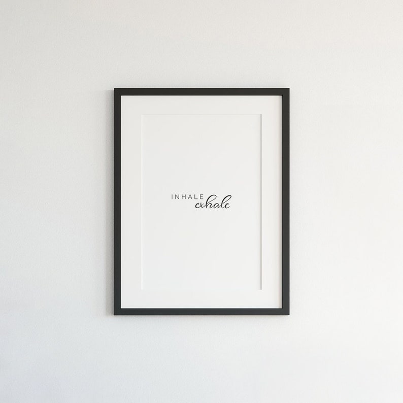 May include: A black framed print with the text "INHALE exhale" in white on a white background.
