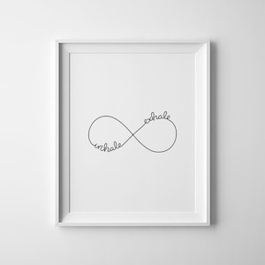 May include: A black and white print featuring the words "inhale" and "exhale" written in a cursive font within an infinity symbol.