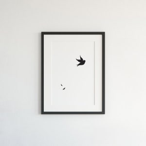 Pu&ograve; includere: Una stampa in bianco e nero di un uccello in volo con due forme nere pi&ugrave; piccole sotto, incorniciata in una cornice nera.