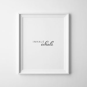 May include: White framed print with the text "INHALE exhale" in black cursive font.