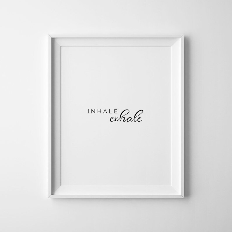 May include: White framed print with the text "INHALE exhale" in black cursive font.