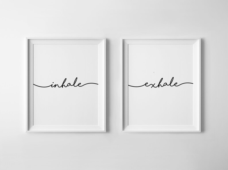 May include: Two framed art prints with the words "inhale" and "exhale" in elegant black script. The minimalist design features a white background and a simple, flowing font, suitable for home decor.