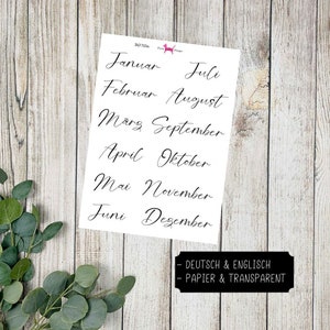 Könnte beinhalten: Ein Blatt weißes Papier mit den Monaten des Jahres in Deutsch und Englisch. Der Text ist in schwarzer Schreibschrift. Das Papier ist mit "DEUTSCH & ENGLISCH" und "PAPIER & TRANSPARENT" beschriftet.