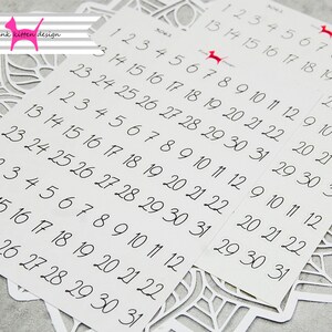 May include: A sheet of white paper with black numbers 1 through 31 printed on it. The numbers are arranged in rows and columns, with each row containing the numbers 1 through 31. The numbers are printed in a handwritten font.