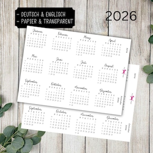 May include: White calendar sheets for the year 2026, featuring monthly layouts in a minimalist design. The text "DEUTSCH & ENGLISCH - PAPIER & TRANSPARENT" is at the top. The year 2026 is displayed in black. A sprig of greenery is in the background.