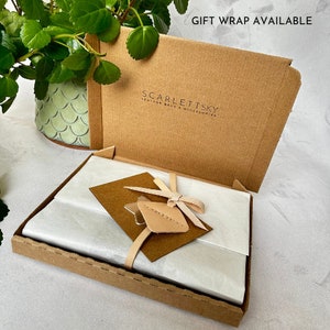 Open box displaying branded gift wrap and card