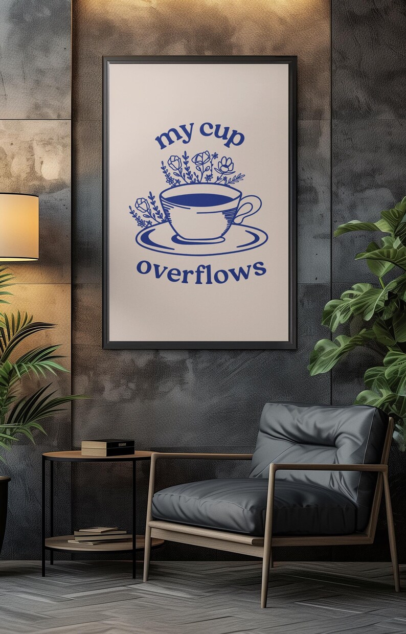 May include: A framed print with a blue illustration of a cup overflowing with flowers. The text "my cup overflows" is written below the cup.