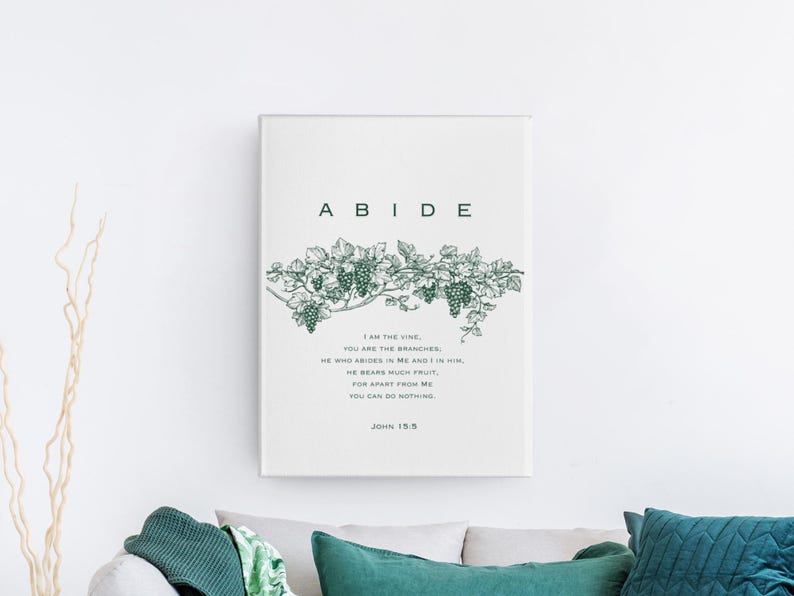 May include: A white canvas print with the word "ABIDE" in large, bold, green letters. A green vine with grapes is depicted above the text. The text below the vine reads "I am the vine, you are the branches. He who abides in me and I in him, he bears much fruit, for apart from me you can do nothing. John 15:5"
