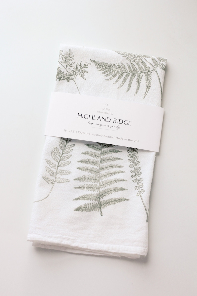 Fern Fronds Tea Towel for the kitchen. A white flour sack tea towel is covered by a variety of large sage green fern fronds