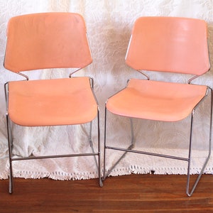 May include: Two peach-colored leather chairs with chrome frames. The chairs are on a white rug with fringe.