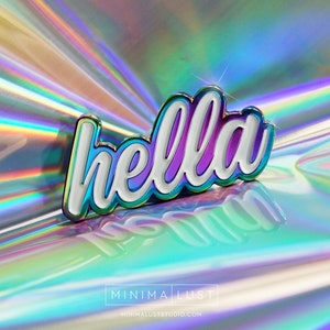 May include: A shiny enamel pin with the word "hella" in white, outlined in iridescent colors and a gold border. The pin is set against a holographic background, reflecting various colors. The pin is a decorative accessory.