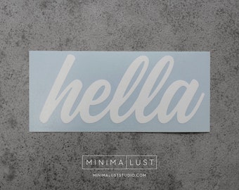 May include: A white vinyl decal with the word "hella" in a cursive font, set against a light blue background. The decal is rectangular and features the "MINIMA LUST" logo and website address at the bottom.