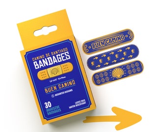 Può includere: Una scatola di 30 cerotti Camino de Santiago con un design blu e oro. I cerotti misurano 3,8 x 1,9 cm e sono privi di lattice e resistenti all'acqua. La scatola presenta anche il testo "Buen Camino".