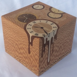 May include: A wooden box with a unique design featuring four clocks, one of which is melting down the side of the box. The clocks are made of wood and have Roman numeral markings.