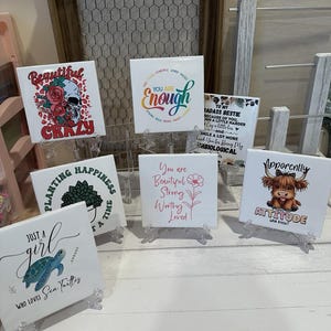 May include: A collection of colorful ceramic tiles with inspirational quotes and designs. The tiles feature phrases like "You are Enough", "Planting Happiness", "Just a Girl Who Loves Sea Turtles", "You are Beautiful Strong Worthy Loved", and "Apparently I Have an Attitude".