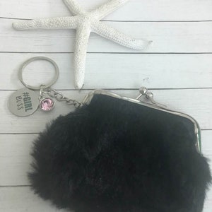 May include: A black faux fur coin purse with a silver clasp and a silver keychain with a pink rhinestone charm and a silver tag that says "#girlboss".