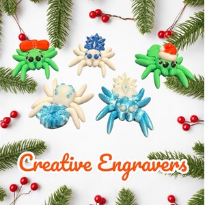 May include: A collection of colorful spider ornaments with festive details, including bows and Santa hats. The spiders are green, white, and blue, set against a backdrop of evergreen branches and red berries. The text "Creative Engravers" is displayed.