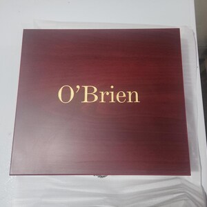 May include: A rectangular, wooden box with a dark red finish. The name "O'Brien" is displayed in gold lettering on the top of the box. The box is closed and appears to be new.
