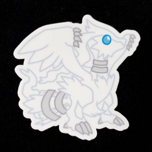 May include: White sticker of a cartoon dragon with a blue eye. The dragon has wings and a tail.