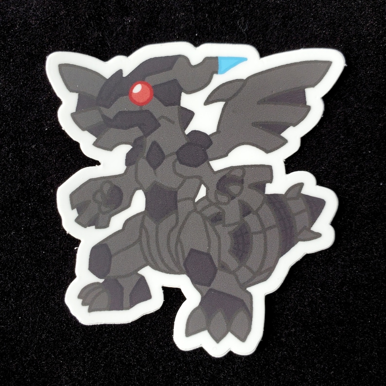 May include: A black and gray cartoon sticker of a Pokemon character with a red eye. The character has wings and a tail.