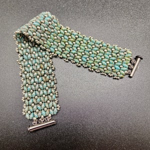 May include: A turquoise and silver beaded bracelet with a toggle clasp.